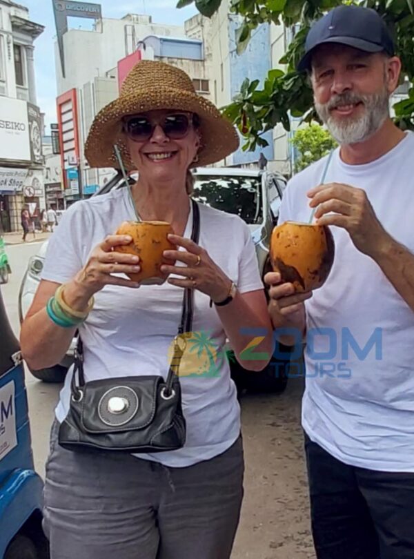 A couple enjoying a refreshing king coconut during a break on their Colombo City Highlights tuk tuk tour.