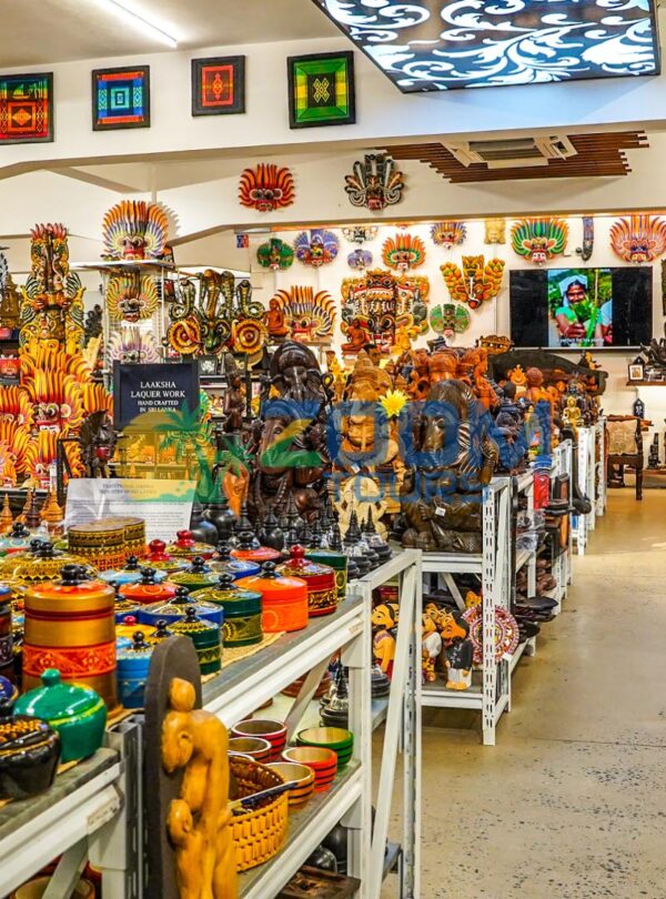 Tourists browsing handmade wooden carvings, batik fabrics, and local souvenirs at a shop in Colombo.